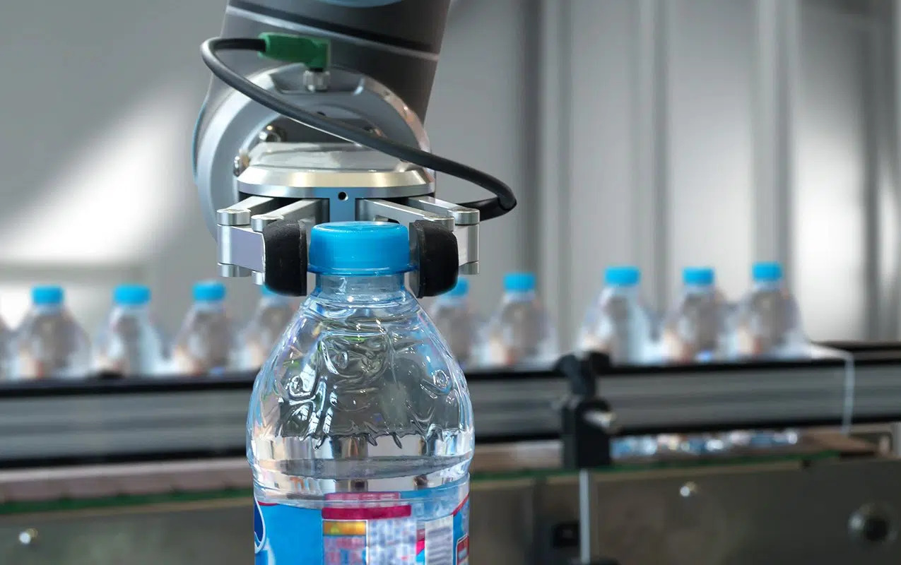 cobot used in manufacturing - attaching caps to water bottles